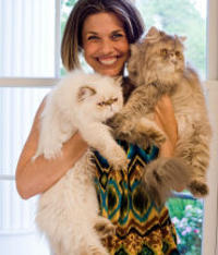 A lady holding 2 cats
